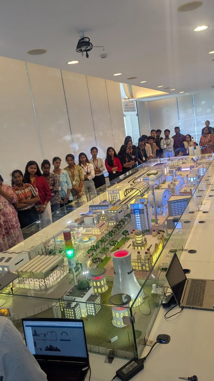 Students examining a detailed facility model during a guided visit